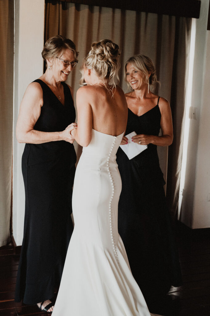 Bride getting ready with two women in black gowns at Casa Cosmos, Puerto Vallarta wedding