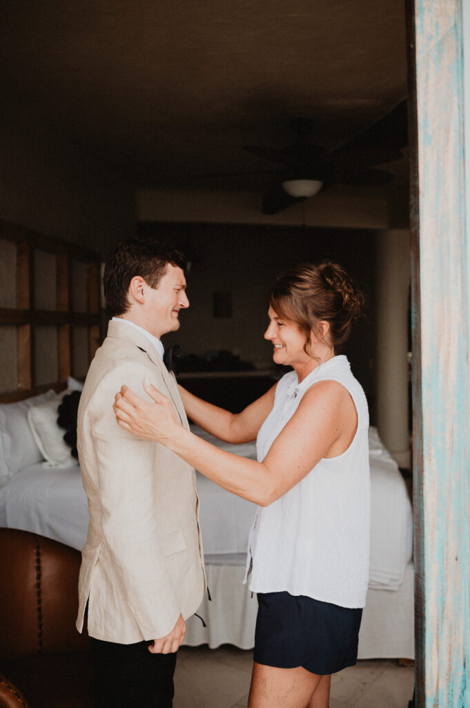 Mother adjusting groom's linen blazer before wedding ceremony at Casa Cosmos Puerto Vallarta