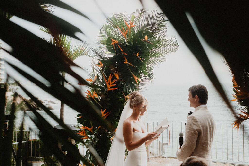 Bride reading vows at tropical outdoor ceremony, Casa Cosmos Puerto Vallarta, with bird of paradise flowers