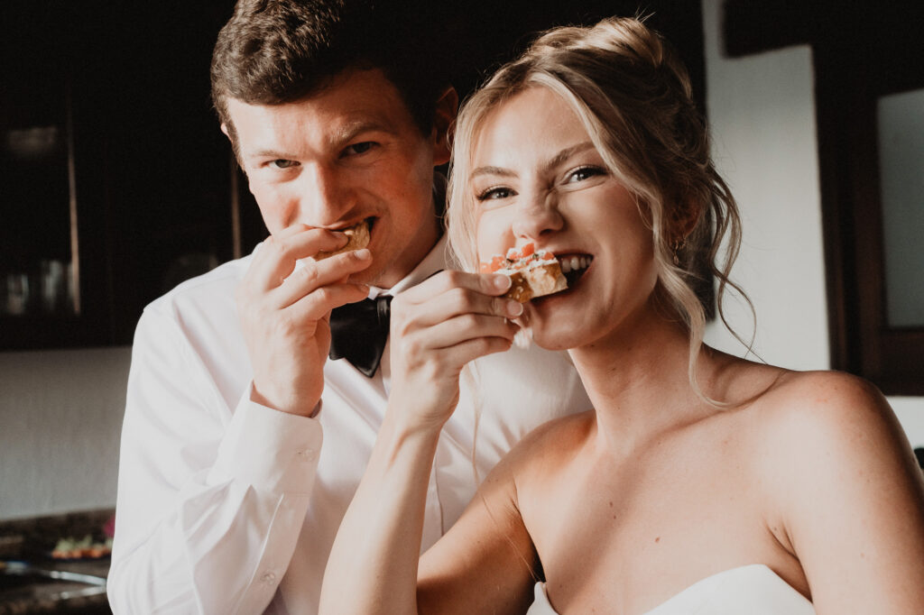 Bride and groom laughing while eating appetizers at their wedding reception at Casa Cosmos, Puerto Vallarta