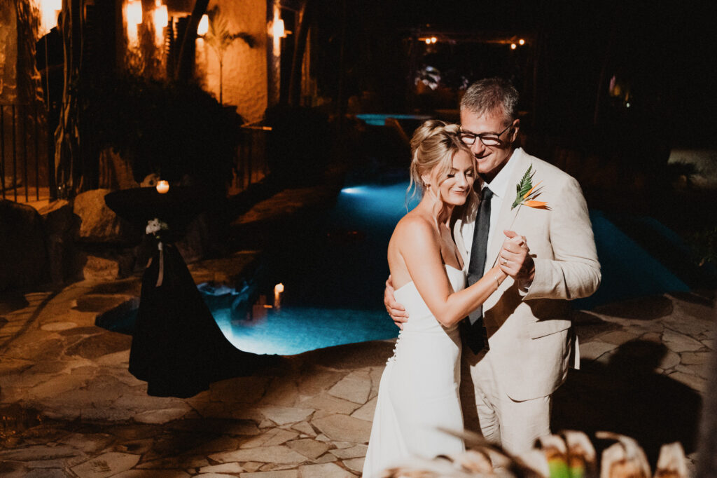 Couple sharing first dance at night beside illuminated pool at Casa Cosmos, Puerto Vallarta wedding reception
