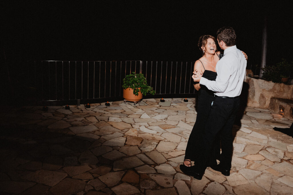 Couple dancing and laughing at night reception on stone terrace at Casa Cosmos Puerto Vallarta wedding
