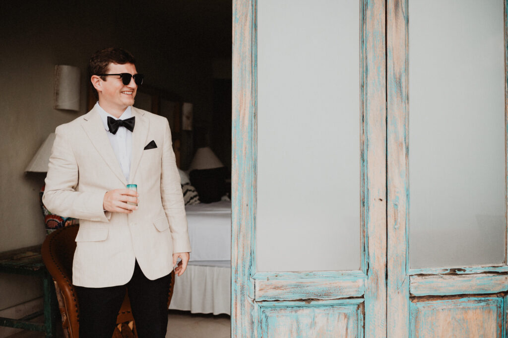 Groom in cream blazer and bow tie laughing at Casa Cosmos, Puerto Vallarta wedding photography