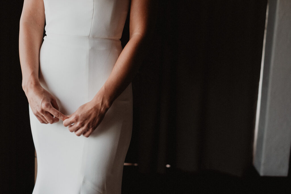Bride adjusting her fitted white gown before wedding ceremony at Casa Cosmos, Puerto Vallarta