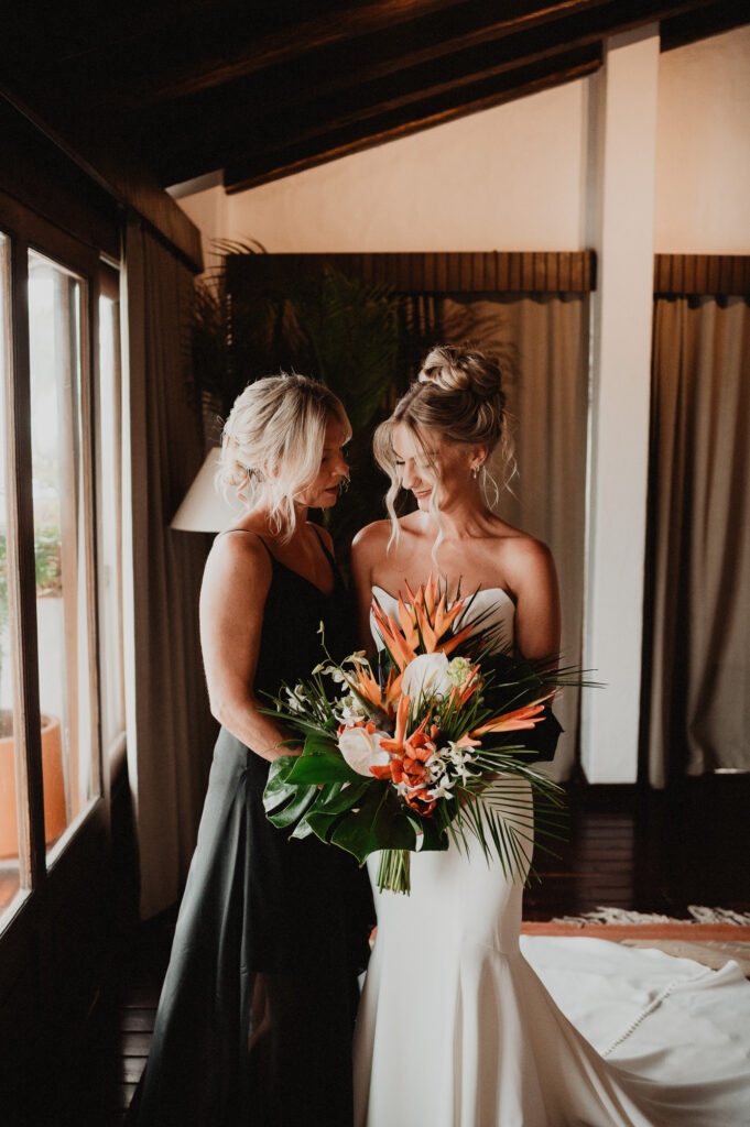 Bride and bridesmaid admiring tropical bouquet at Casa Cosmos, Puerto Vallarta wedding