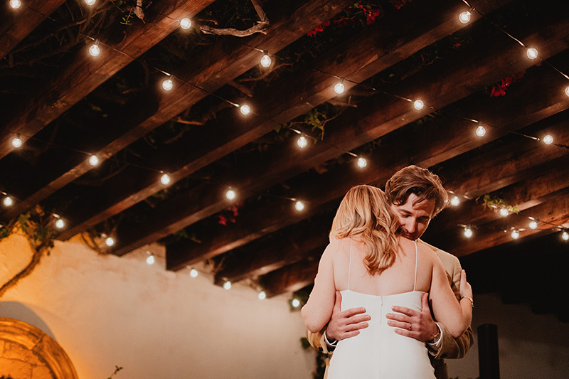 Couple sharing first dance under string lights and wood beams at San Miguel de Allende wedding reception