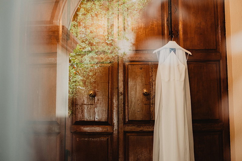 Wedding dress hanging on antique wooden doors, San Miguel de Allende wedding ceremony, documentary film photography