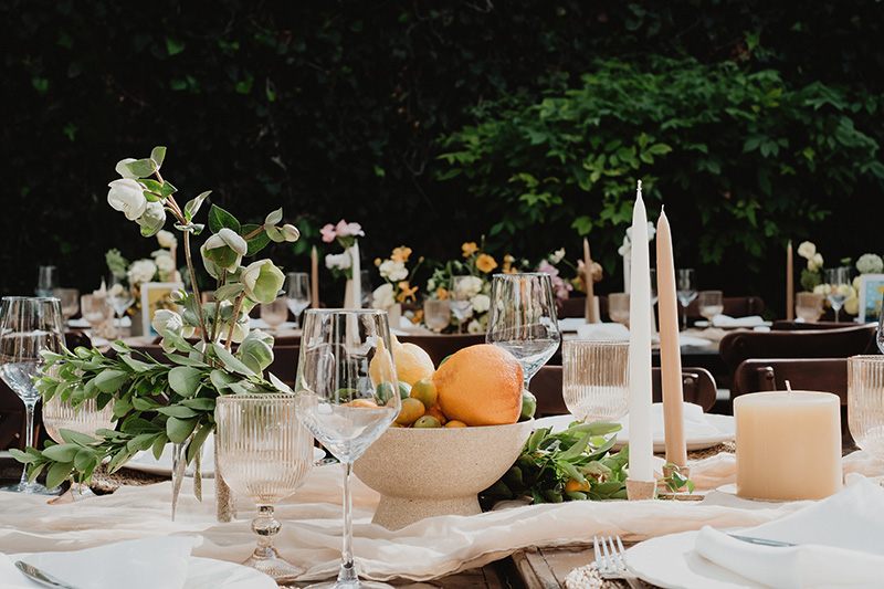 Wedding reception table with citrus bowl, candles, and greenery in San Miguel de Allende