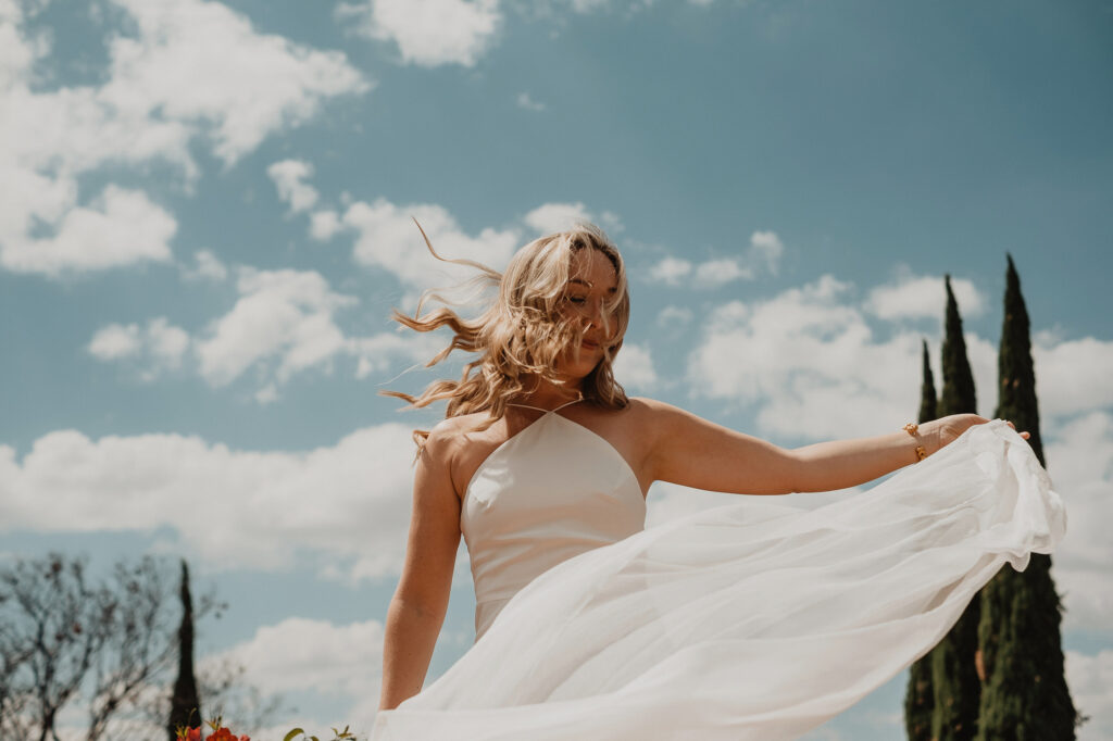 Bride in white halter gown twirling outdoors at San Miguel de Allende wedding, film photography style