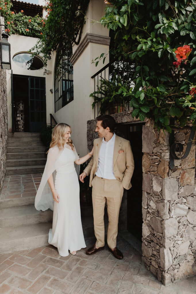 Bride and groom laughing together at a stone doorway during their San Miguel de Allende wedding ceremony