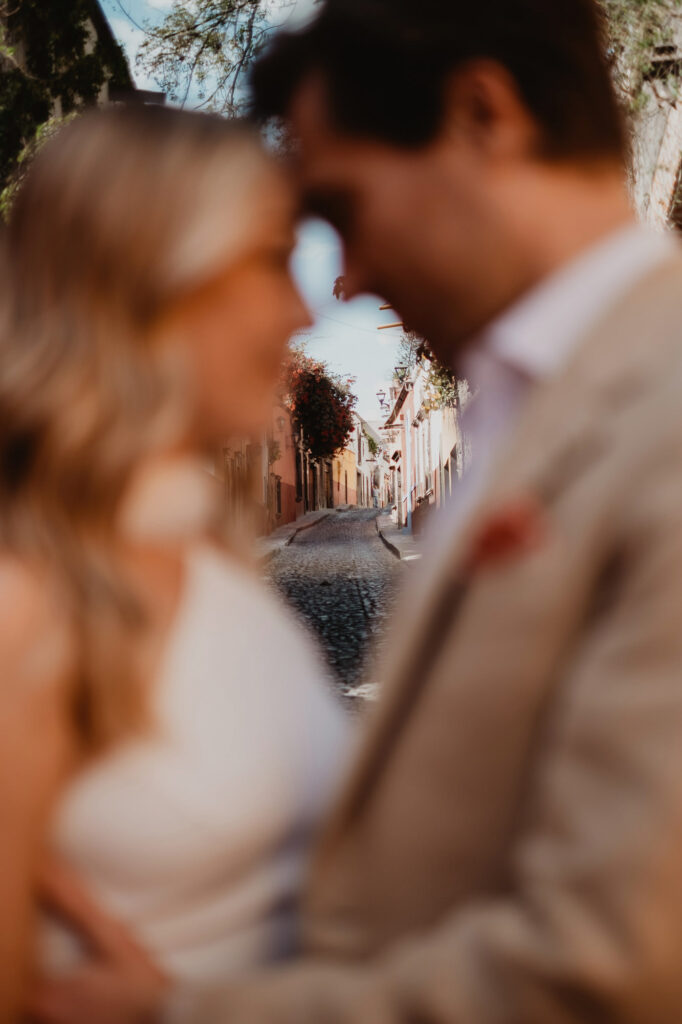 Couple sharing an intimate moment on a cobblestone street in San Miguel de Allende during their wedding day
