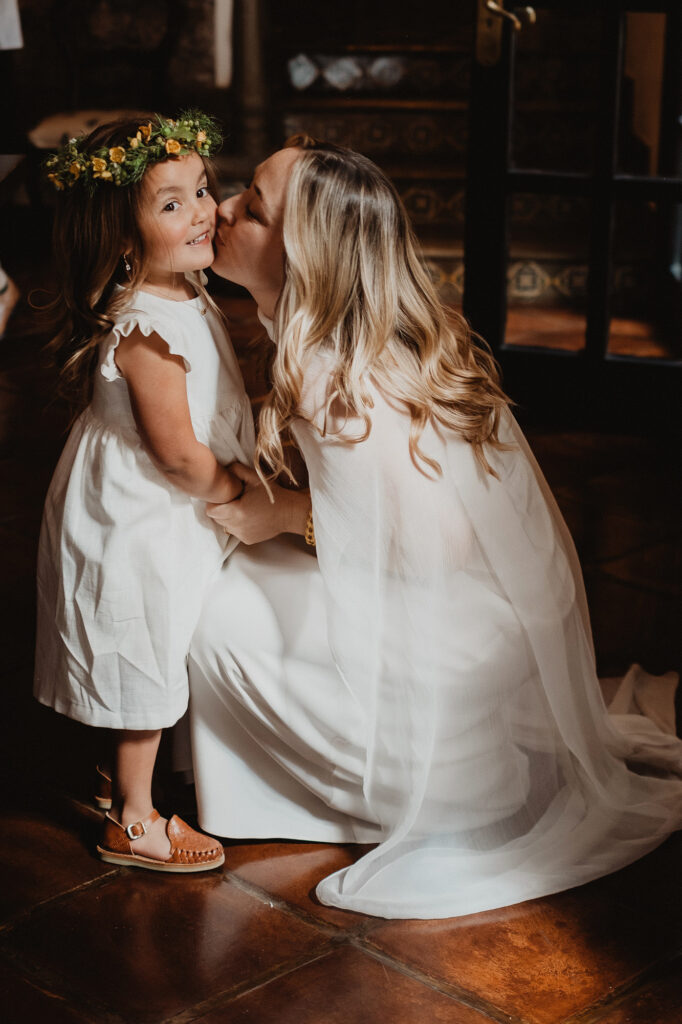 Bride kisses flower girl in white dress and floral crown, wedding ceremony, San Miguel de Allende