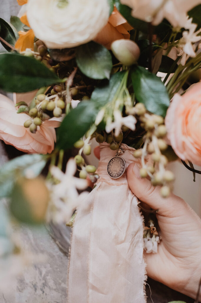 Bridal bouquet with peach roses and a silver locket charm, San Miguel de Allende wedding detail