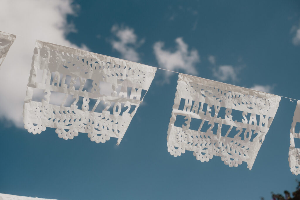 Custom papel picado banners reading Haley & Sam with wedding date at San Miguel de Allende reception