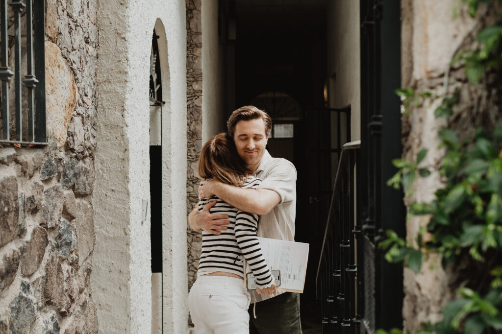 Couple embracing at stone archway entrance during San Miguel de Allende wedding ceremony, documentary style