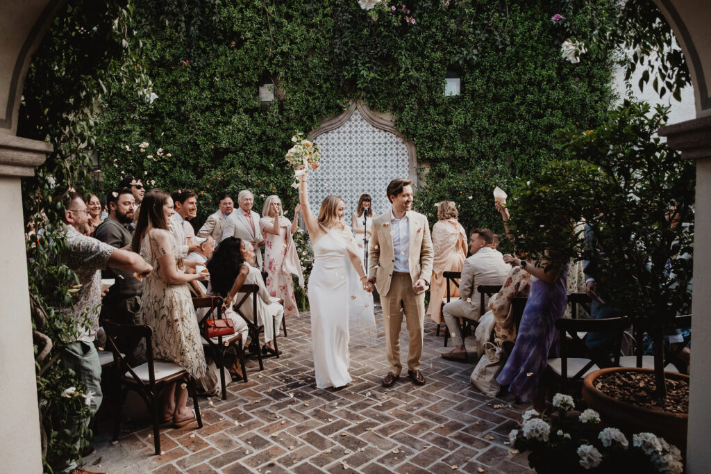 Couple walks down the aisle after ceremony at a lush courtyard wedding in San Miguel de Allende