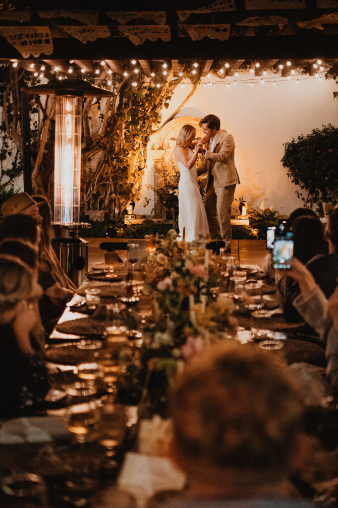 Couple sharing first dance at wedding reception in San Miguel de Allende, warm string lights and floral table