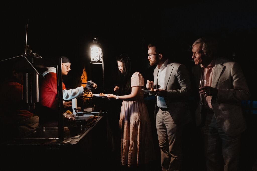 Guests served at outdoor food station during San Miguel de Allende wedding reception at night