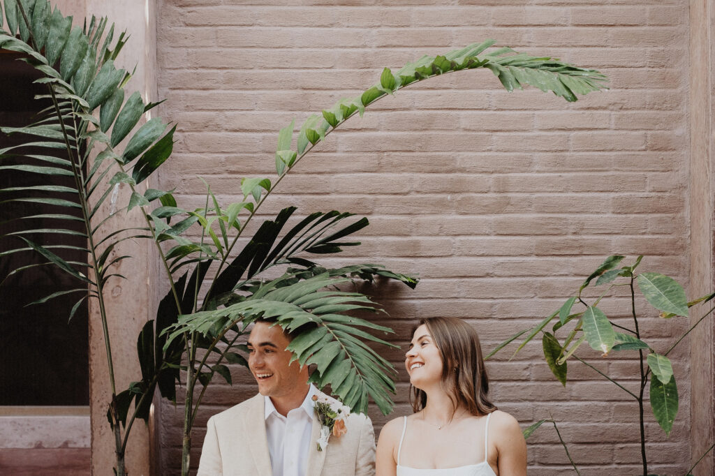 Couple laughing together during elopement at Rosa Morada, San Pancho, surrounded by tropical plants