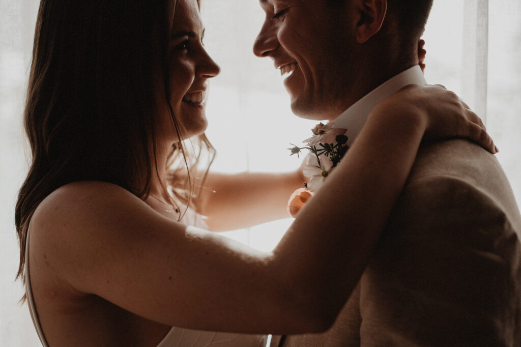 Bride pinning boutonniere on groom during elopement in San Pancho, Rosa Morada, Mexico