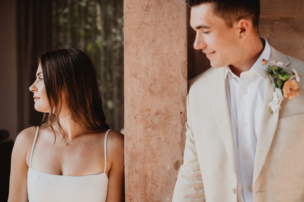 Bride and groom separated by stone column at Rosa Morada, San Pancho elopement photographed by Alex Obregón