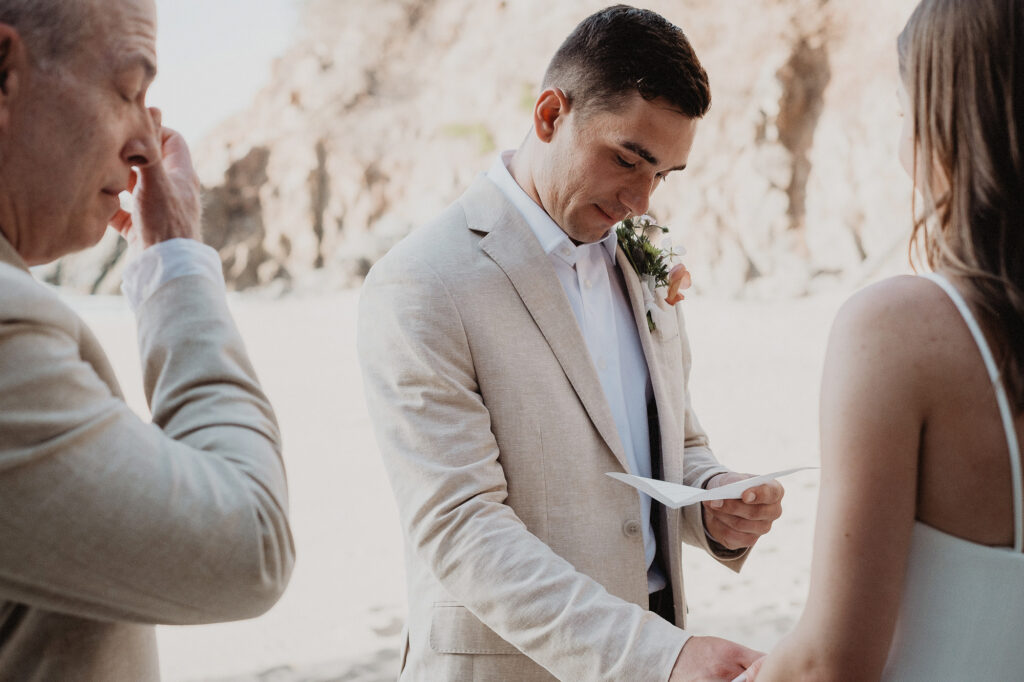 Groom reads wedding vows during beach elopement in San Pancho, Rosa Morada, Mexico