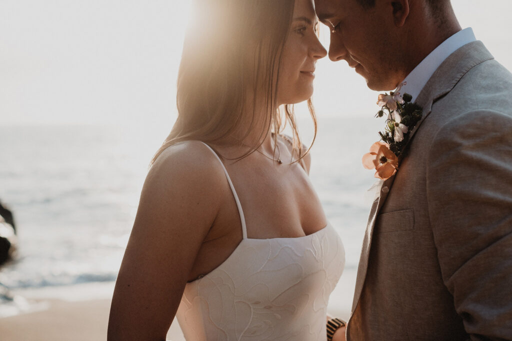 Bride and groom sharing an intimate moment at sunset on the beach in San Pancho, Mexico elopement