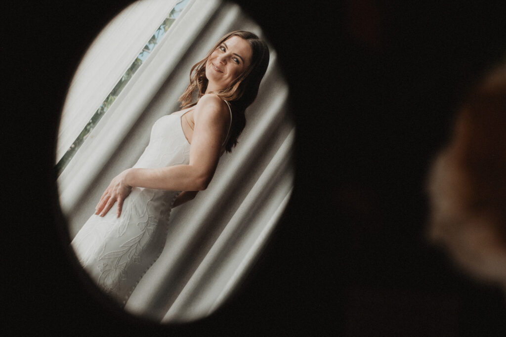Bride in white embroidered gown reflected in round mirror, elopement in San Pancho Mexico