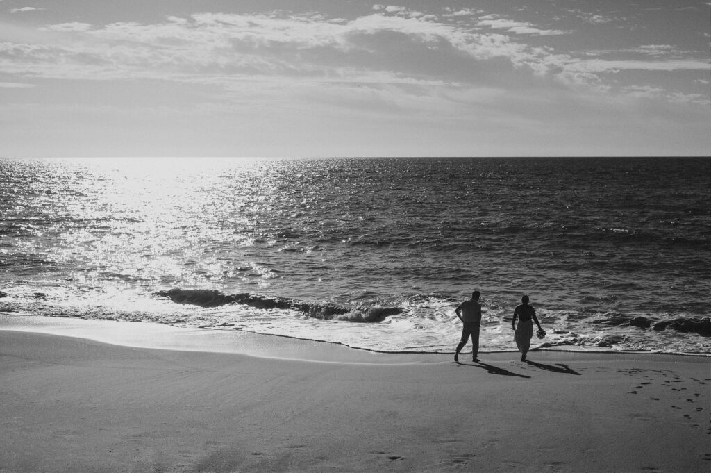Elopement couple walking along the shoreline at Villa Amor Sayulita, black and white beach wedding photo