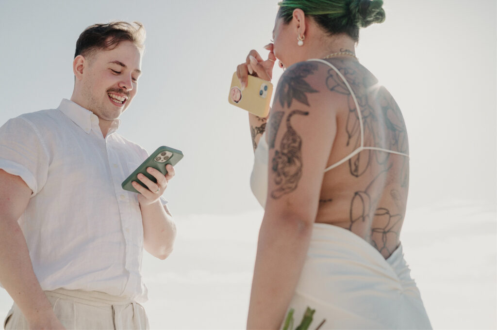 Couple laughing and reading vows from phones during elopement at Villa Amor Sayulita Mexico