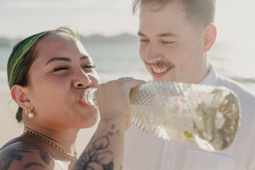 Couple sharing a drink on the beach during elopement at Villa Amor Sayulita Mexico