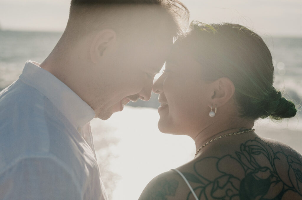 Couple sharing an intimate forehead touch at sunset on the beach during a Sayulita elopement