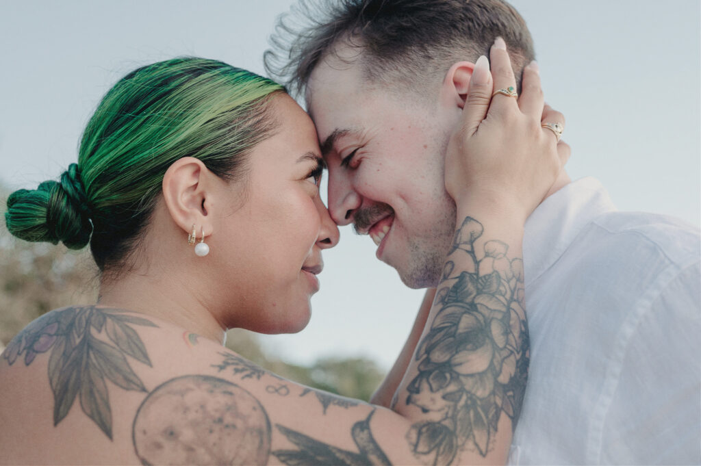 Couple touching foreheads and smiling during elopement at Villa Amor Sayulita, both with tattoos