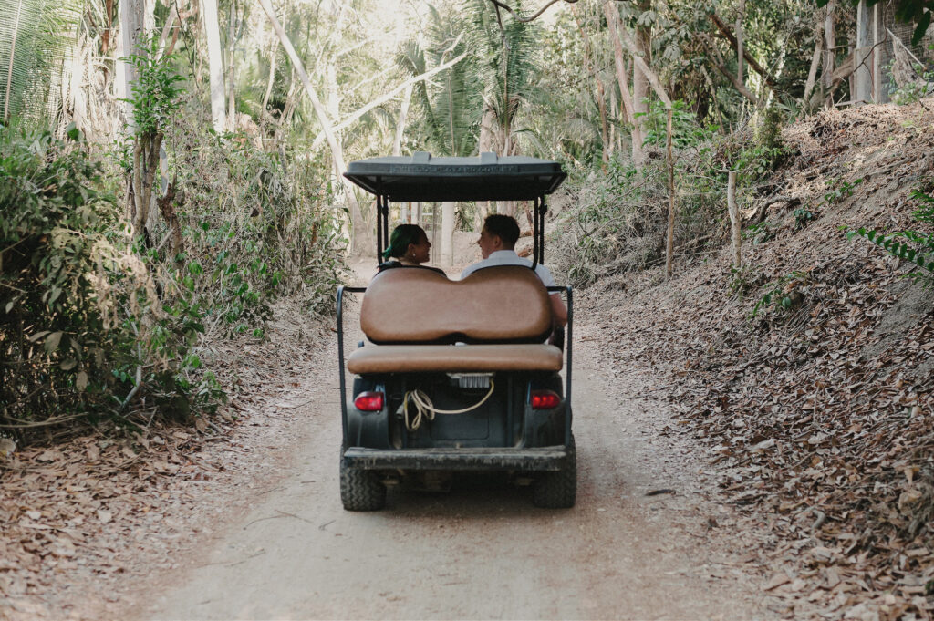 Couple riding golf cart through jungle path at Villa Amor Sayulita elopement, shot by Alex Obregón
