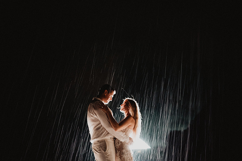 Couple dancing in the rain at night during wedding reception at One&Only Mandarina, Mexico