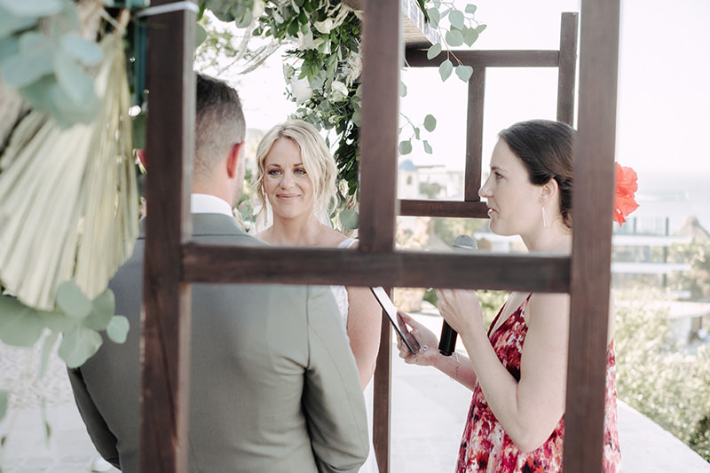 Bride smiling at groom during outdoor wedding ceremony at Villa Amor Sayulita with floral arch