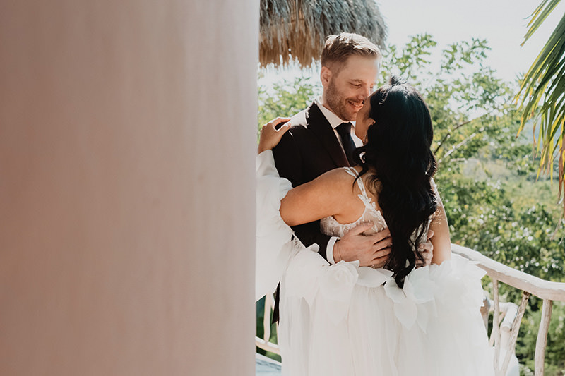 Bride and groom embrace laughing at Villa Valentin Sayulita wedding, lush jungle backdrop