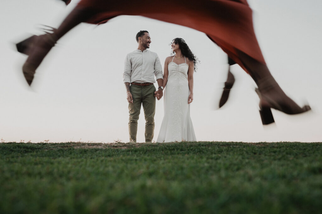Bride and groom hold hands smiling at each other at Frente al Punto, Sayulita wedding ceremony