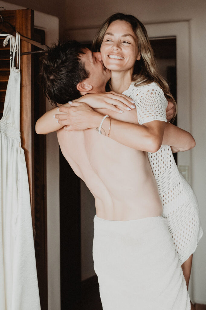 Couple embracing and laughing in wedding suite at Villa del Sol Sayulita, documentary wedding photo