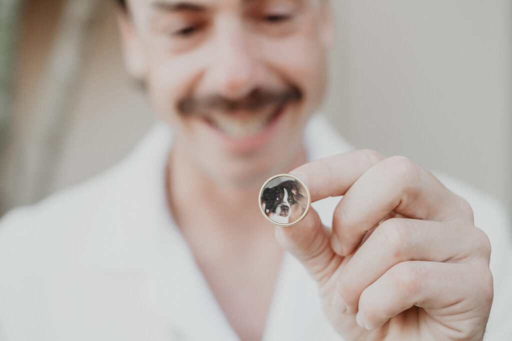 Groom smiling holding custom dog photo wedding ring at Villa del Sol Sayulita ceremony
