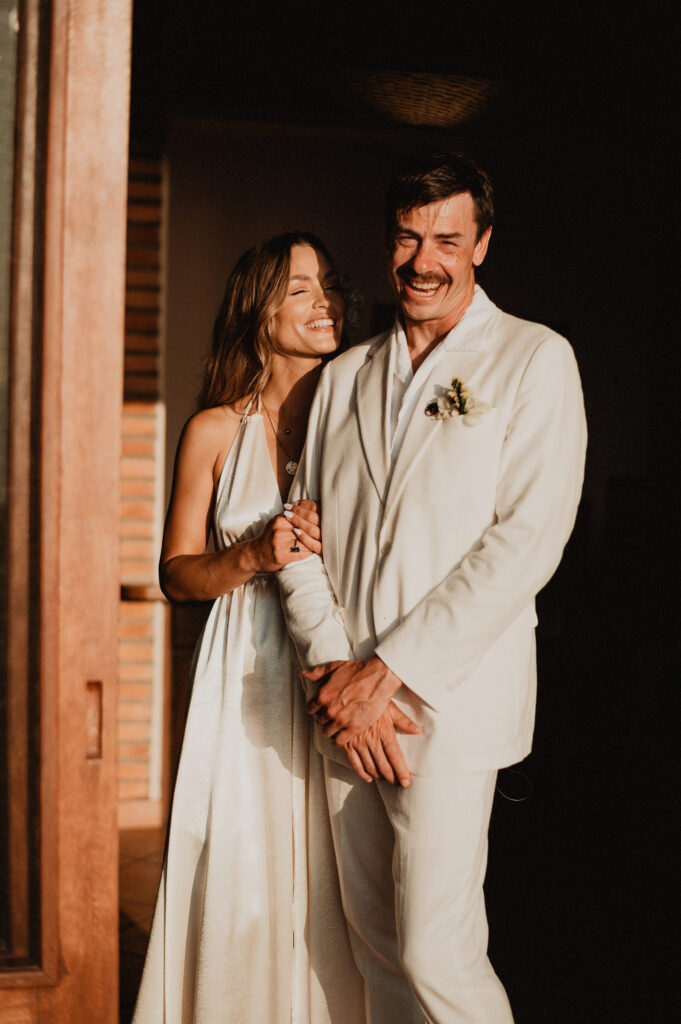 Bride and groom laughing together at Villa del Sol, Sayulita wedding reception, golden hour light
