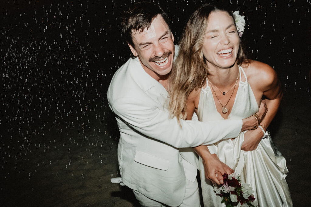Bride and groom laughing in the rain at night, Villa del Sol Sayulita wedding reception