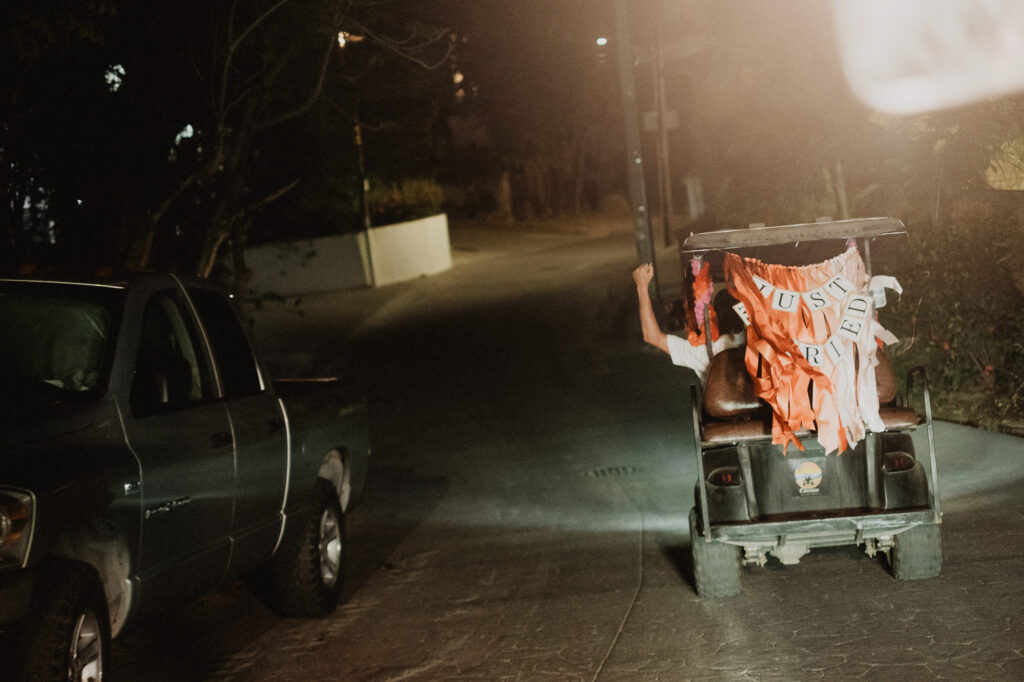Just Married golf cart decorated with orange ribbons at night, Villa del Sol Sayulita wedding reception