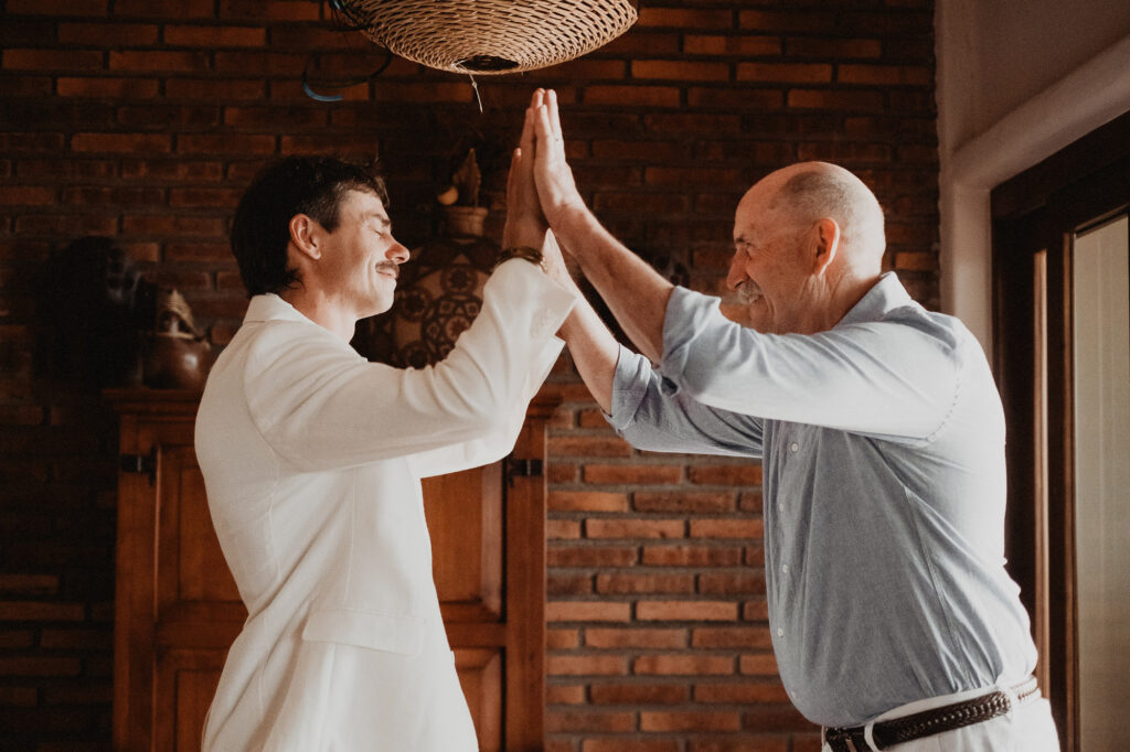 Groom high-fiving father before wedding ceremony at Villa del Sol, Sayulita, Mexico