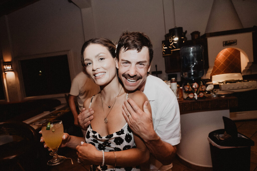 Couple laughing and embracing at Villa del Sol reception, Sayulita wedding photography by Alex Obregón
