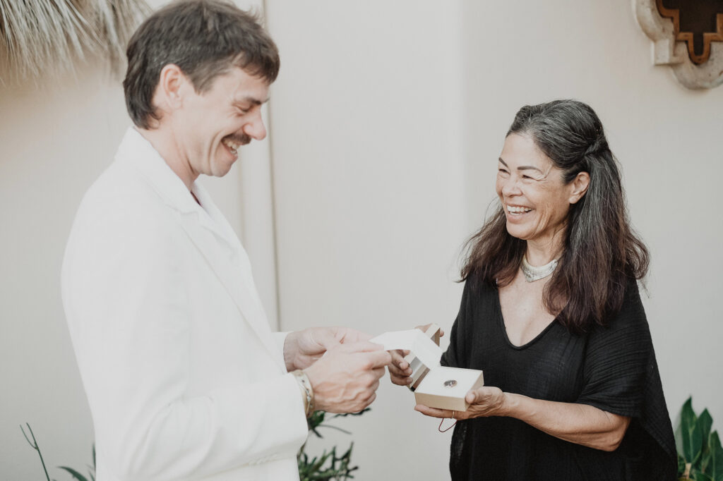 Couple laughing while opening wedding rings box at Villa del Sol Sayulita ceremony