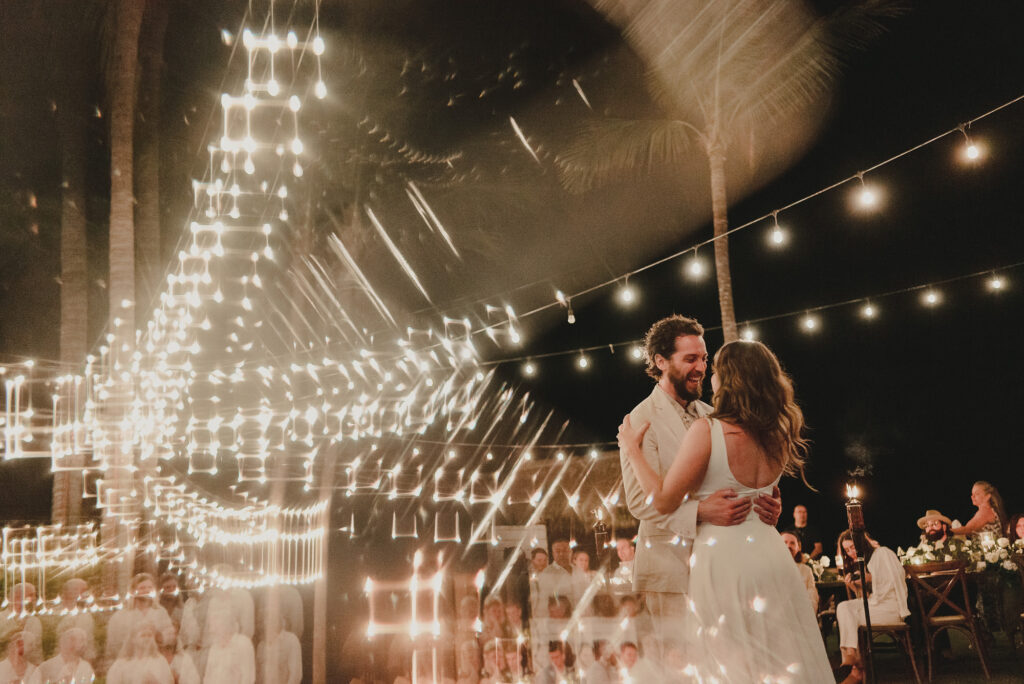 Couple sharing first dance under chandelier lights at Frente al Punto Sayulita wedding reception