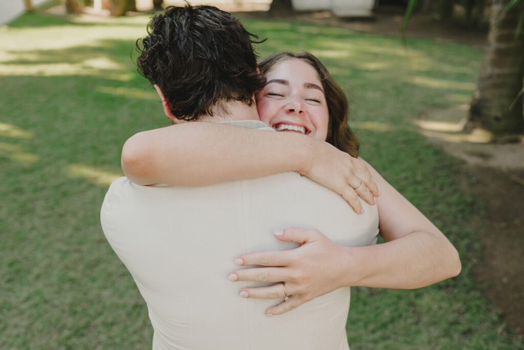 Bride laughing with joy during wedding hug at Frente al Punto, Sayulita, photographed by Alex Obregón
