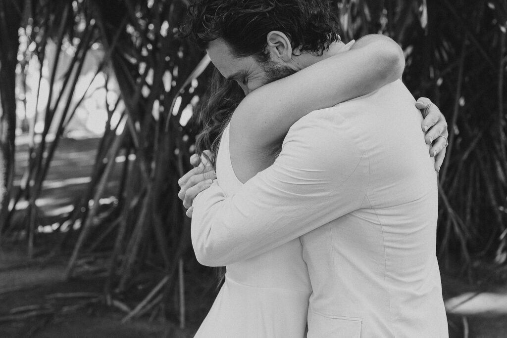 Bride and groom embrace during wedding ceremony at Frente al Punto, Sayulita, captured in black and white