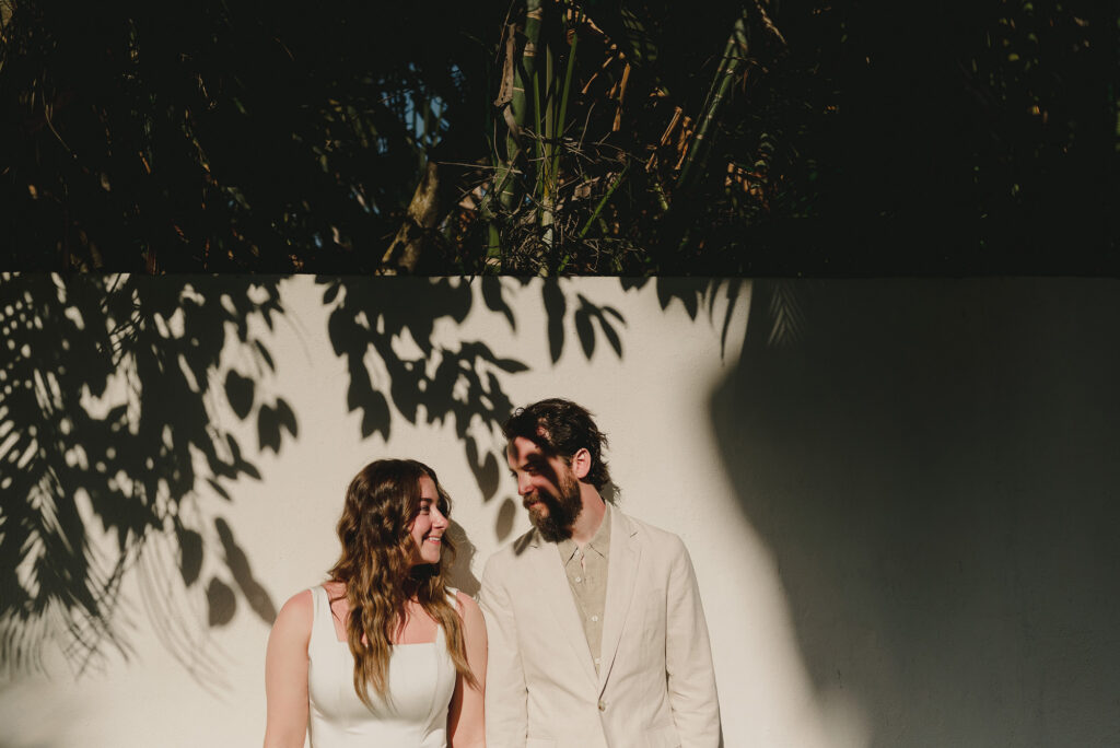 Bride and groom share a quiet moment at Frente al Punto, Sayulita wedding, tropical leaf shadows on white wall